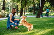 © teksomolika - Portrait of woman with dog Welsh Corgi Pembroke in dog park