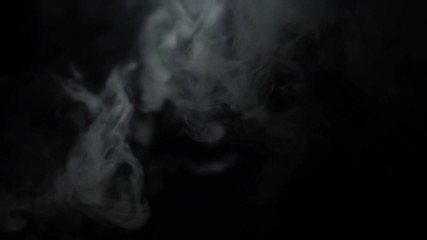 Poster - Close-up of white puffs of smoke in the dark on the black background. Action. Smoke in darkness