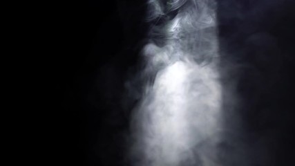 Poster - Close-up of white puffs of smoke swirling in a beam of light in the dark room. Action. Smoke in darkness