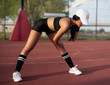 © phoenix021 - Attractive female in sports clothes stretching on sports court