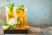 Traditional Iced Tea With Lemon And Ice In Tall Glasses On A Wooden Rustic Table. With Copy Space