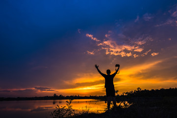 Wall Mural - Silhouette photographer at sunset on the lake landscape