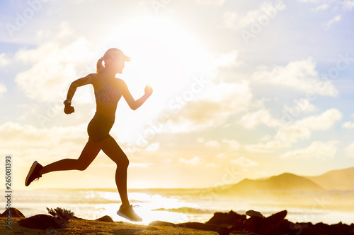 Fotomural Summer workout athlete runner girl trail running on summer beach