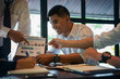 © bunyarit - Successful businessman boss presenting new project to employees, businessman giving presentation to clients in meeting room, team leader reporting about work explaining result on flipchart.