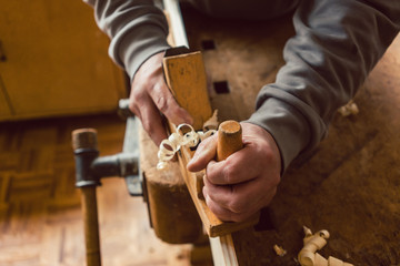 Top view of carpenter hand working with wood planer