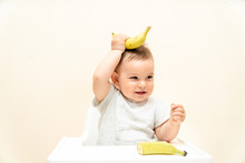 Funny Little Toddler Eating Banana In A High Chair Copy Space Food Baby
