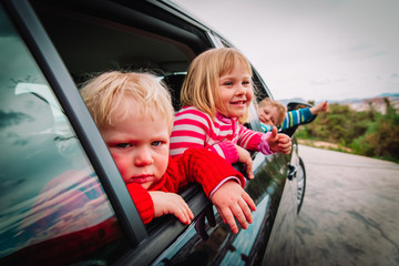 cute kids travel by car on road in nature