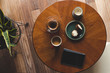A top down shot of modern living room coffee table with a coffee cup, book, tablet, and a muffin on it.