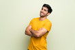 © luismolinero - Young man over pink wall keeping the arms crossed while smiling