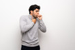 Young man over isolated white wall is suffering with cough and feeling bad