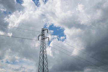 Electric power pole in the cloudy sky