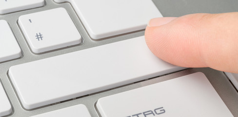 Wall Mural - a finger clicking an unlabeled button on a keyboard