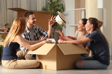 Canvas Print - Happy roommates joking unboxing belongings moving home