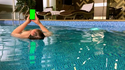 middle age man using smartphone in the pool