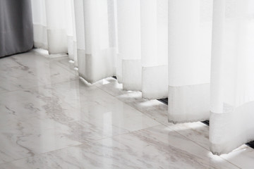 Wall Mural - white transparent curtain over marble floor. lace curtain of house window.