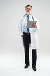 © opolja - full body picture of a mature doctor holding a notepad, on white background.