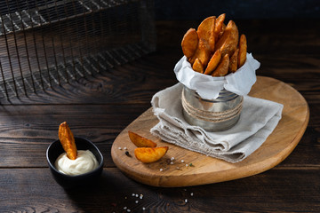 Wall Mural - Fried Country-style Potato wedges, salt and sauce on wooden background. Copy space