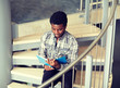 © Syda Productions - education, high school, university, learning and people concept - happy african american student boy or young man reading book sitting on stairs