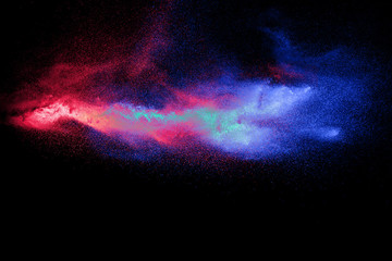 Wall Mural - color powder explosion cloud on black background. freeze motion of color dust particles splashing.