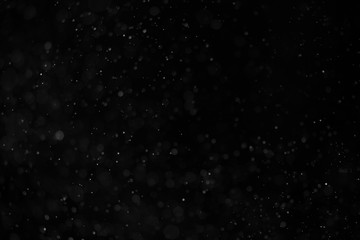 Abstract real dust floating over black background