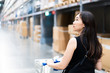 © DG PhotoStock - Beautiful Asian woman's portrait in warehouse.  Asian woman looking for the items on shelf close up.