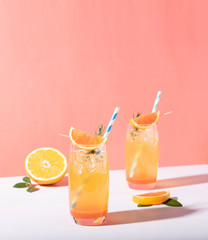 Cold and refreshing orange punch cocktail with orange slice on color background. summer drink.