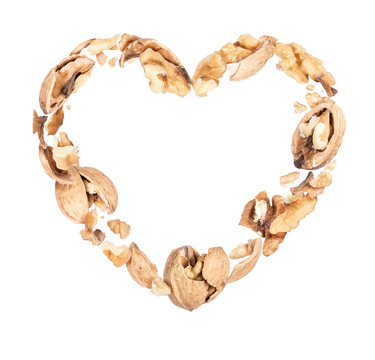 Crushed walnuts in the air in the shape of a heart, isolated on a white background