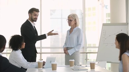 Wall Mural - boss welcoming new partner at meeting handshaking congratulating with promotion