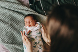 young mother swaddling a newborn baby