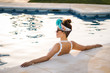 © Patricia Becaroto/ADDICTIVE STOCK - Young rich chinese woman relaxing swimming in a pool at a luxurious resort