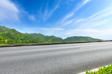 Country road and green mountains natural landscape under the blue sky