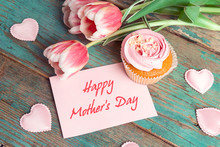 Mothers Day Message On Pink Card With Cupcake, Tulips And Hearts On Turquoise Wooden Background.