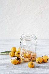 Sticker - compote or syrup from a loquat in a glass jar. Preparation of a syrup from a loquat with sugar. canning fruit.