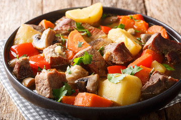 Poster - ragout of pork with mushrooms and vegetables close-up on a plate. horizontal