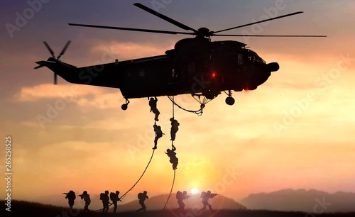 Fotografía Military commando helicopter drops in silhouette during sunset