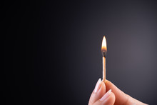 Close Up Woman Hand Holding A Burning Match.