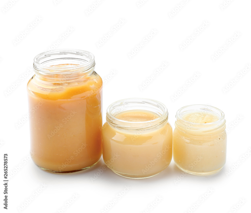 Jars with different healthy baby food on white background