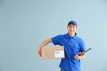 Canvas Print - Delivery man with box on color background