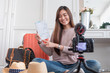 © weedezign - Asian young female blogger recording vlog video with vacation preparing to travel trip at home.online influcencer on social media concept