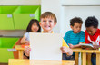 © weedezign - Kid boy holding blank paper with back to school word with diversity friends and teacher at background,Kindergarten school,mock up chalkboard for adding text