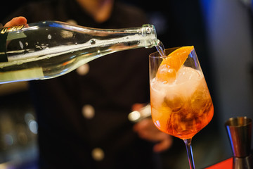 The bartender pours a glass of alcohol