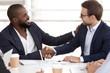 Happy diverse businessmen partners shake hands at meeting negotiations