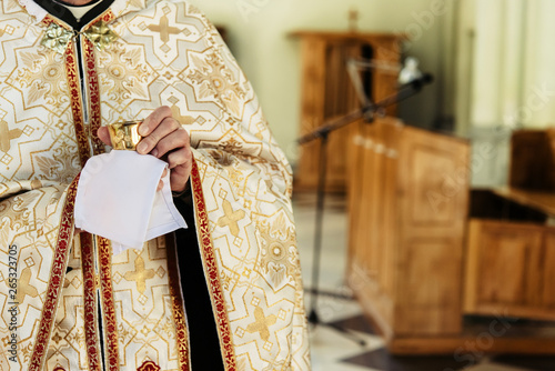 Fotografía priest holding chalice for communion, wedding ceremony of happy elegant blonde