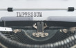 close-up of word IMPRESSUM, German for copyright page or imprint or publishing information, written on old manual typewriter