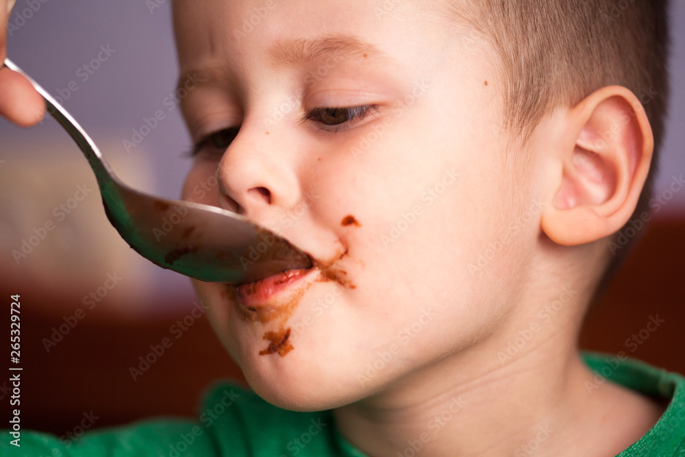 Close up portrait of Cute little boy eating chocolate yogurt at ...