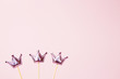 © KsPhoto - Three shiny crowns on a pink background. Decorations for holiday party. Copy space