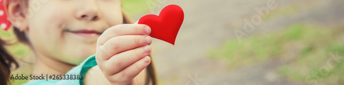 Fotomural The heart is in the hands of the child. Selective focus.