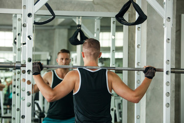 portrait of sporty girl workout on exercise machine in gym. Pretty young man training in the gym