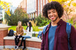 © Designpics - Portrait of a young African American male university student posing with his friends talking together in the background on the university campus; Edmonton, Alberta, Canada