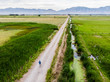 © Designpics - A man walks down a long, straight road with mountains in the distance; Logan, Utah, United States of America